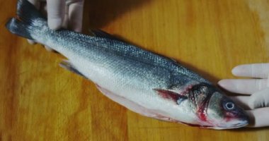 Macro close up of fresh fish on a wooden restaurant kitchen table (close up)