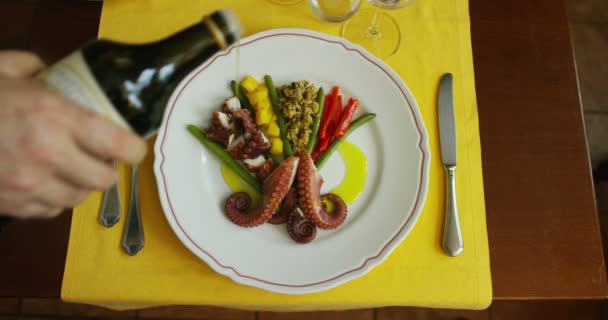 La mano de un cocinero experto termina de adornar el plato de pescado con un gesto delicado, poniendo aceite orgánico — Vídeos de Stock