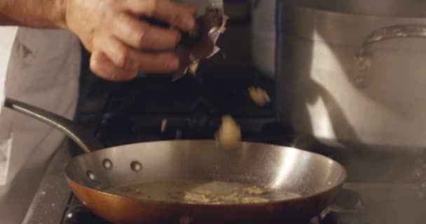 Super slow motion macro of a hand of middle aged chef grating black truffle in pan (close up) — Stock Video