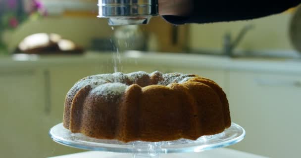 Super lambat gerak makro dari seorang pria setengah baya tukang roti menaburkan bubuk gula putih pada kue (close up ) — Stok Video