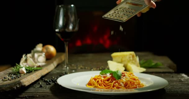 Belle composition de pâtes italiennes dans un ancien chalet traditionnel avec cheminée et atmosphère décontractée avec assiette de chef garniture de fromage parmesan et feuilles de basilic — Video