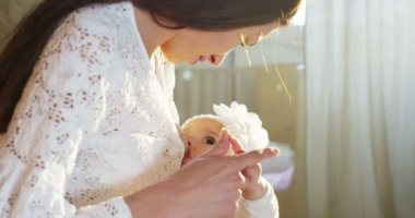 güzel genç anne breastfeeds bir sevimli küçük kız güneşin cilt okşar iken onun oyun odası
