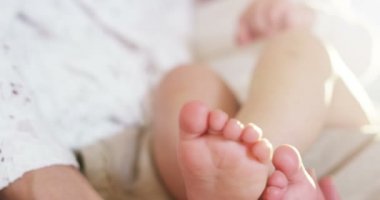 bir anne elinde hafifçe bebek ayakları emzirme sırasında dokunma