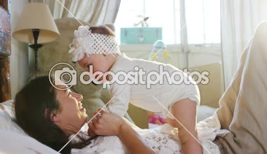 Mutlu anne ve bebek öpüşme ve sarılma, yatak birlikte, annelik konsepti annelik güzel mutlu aile stok Video görüntüleri yavaş dinlenme