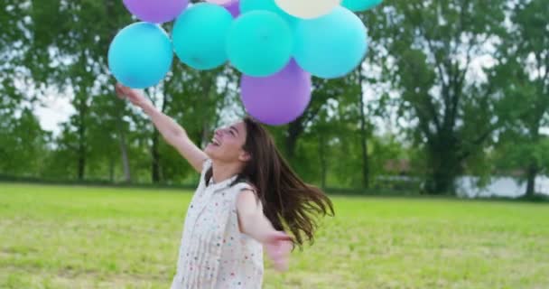 Mujer con globos en el prado — Vídeo de stock
