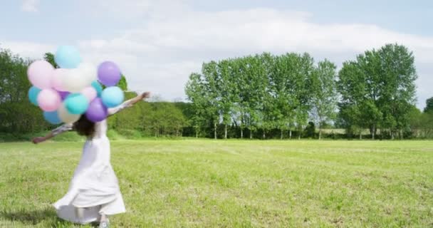Frau mit Luftballons auf der Wiese — Stockvideo