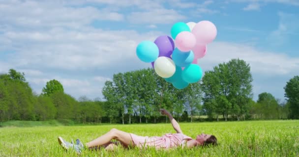 Mujer con globos en el prado — Vídeo de stock