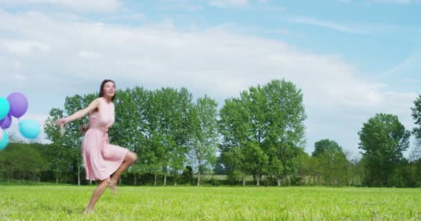 Женщина с воздушными шарами на лугу — стоковое видео