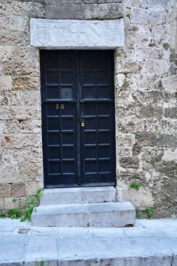 Rodos Şövalyeleri Sokağı, Rodos, Yunanistan 'da oyulmuş kalkanları olan antik bir kapı. Şubat 2025. 