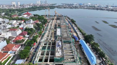 Arka planında vinç ve büyük bir bina olan hava manzaralı bir inşaat alanı. Vinç görüntünün sol tarafında ve bina da sağ tarafında. şehir merkezi 