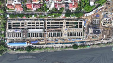 Arka planında vinç ve büyük bir bina olan hava manzaralı bir inşaat alanı. Vinç görüntünün sol tarafında ve bina da sağ tarafında. şehir merkezi 