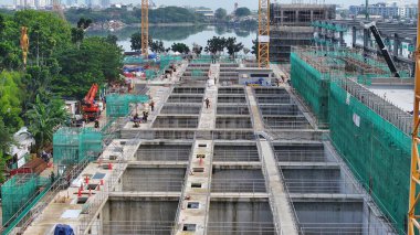 Arka planında vinç ve büyük bir bina olan hava manzaralı bir inşaat alanı. Vinç görüntünün sol tarafında ve bina da sağ tarafında. şehir merkezi 