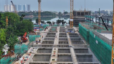 Arka planında vinç ve büyük bir bina olan hava manzaralı bir inşaat alanı. Vinç görüntünün sol tarafında ve bina da sağ tarafında. şehir merkezi 