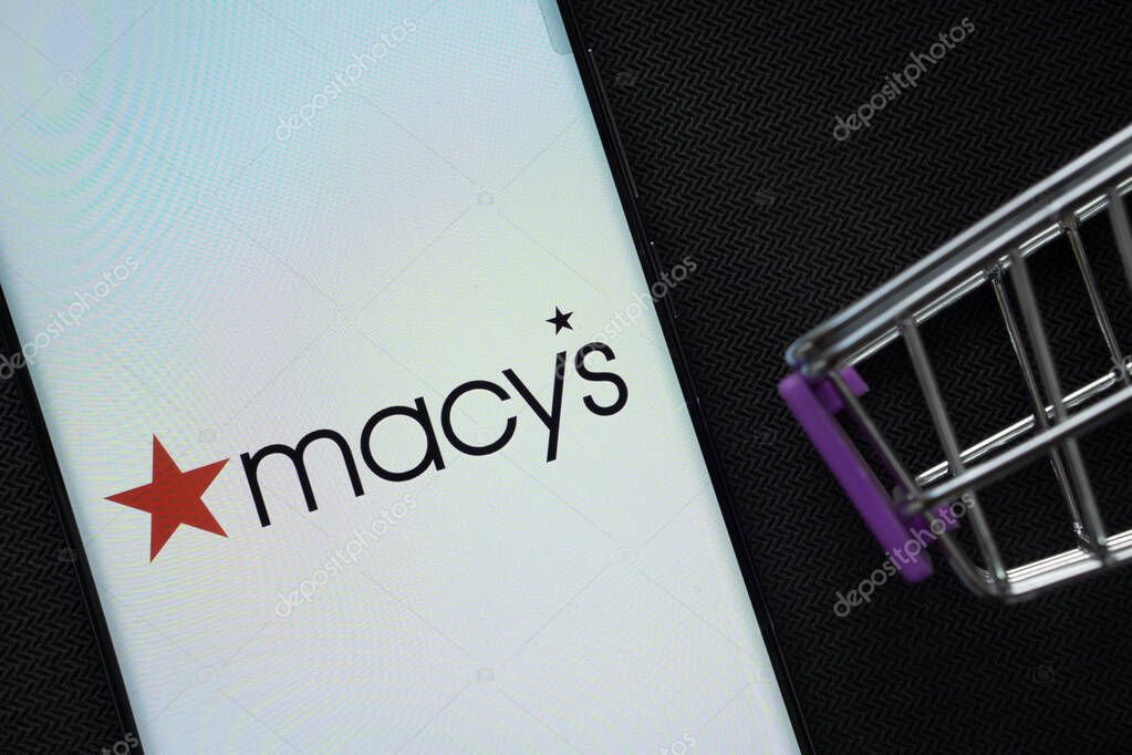 Dhaka, Bangladesh- 03 July 2025: A smartphone displaying the Macy's logo next to a miniature shopping cart on a background