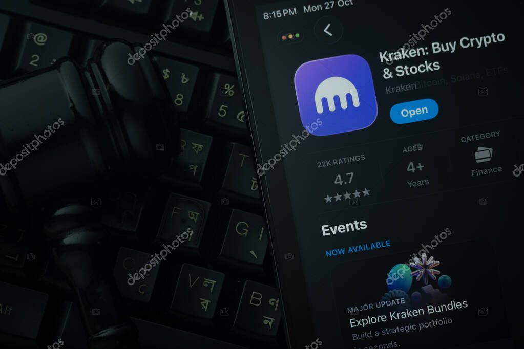 Dhaka, Bangladesh- 28 Oct 2025: An iPad displaying the Kraken app against a judge's gavel and dark keyboard background.