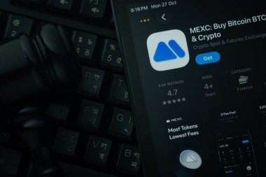 Dhaka, Bangladeş - 28 Ekim 2025: Hakimin tokmağına karşı MEXC uygulamasını gösteren bir iPad.