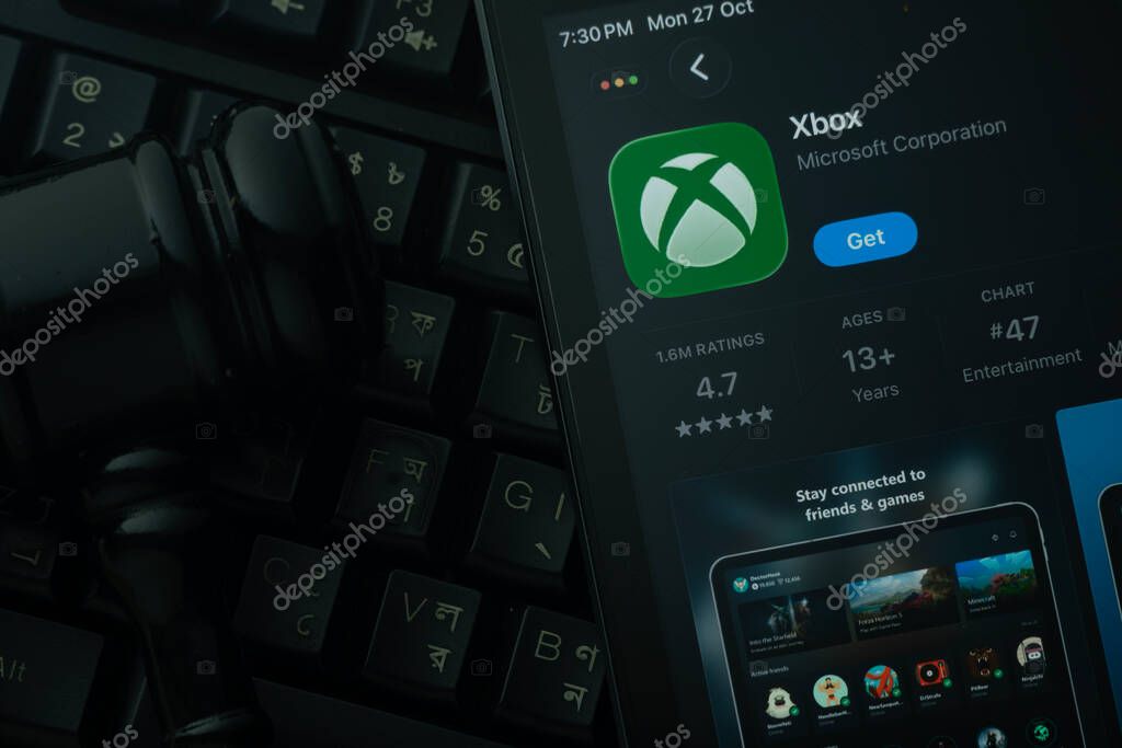 Dhaka, Bangladesh- 28 Oct 2025: An iPad displaying the Xbox app against a judge's gavel and dark keyboard background.