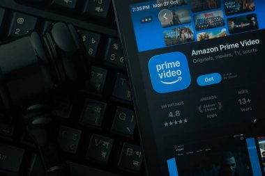 Dhaka, Bangladesh- 28 Oct 2025: An iPad displaying the Amazon Prime Video app against a judge's gavel and dark keyboard background.