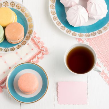 Tatlılar ve beyaz arka plan üzerinde kart ile çay. Seçici odak, üstten görünüm, makro, tonlu görüntü, film etkisi