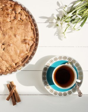 Pasta ile çay ve kardelen Beyaz ahşap zemin üzerinde. Seçici odak, tonlu görüntü, film efekt, en iyi Manzaralı