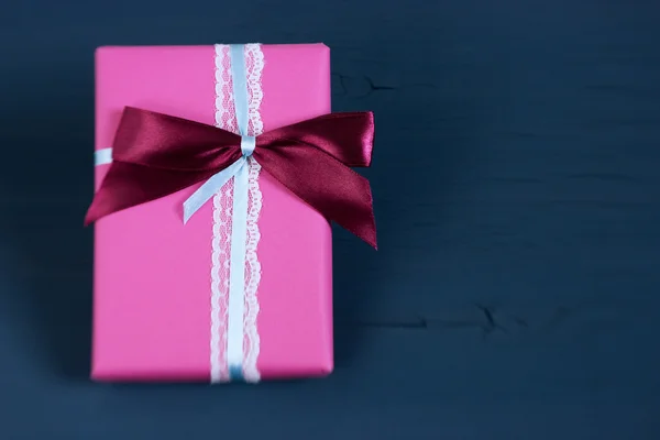 Packed box, gift on a wooden dark-blue background. Selective focus, small depth of field, toned image, film effect