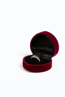 Beyaz zemin üzerine kırmızı hediye kutusunda nişan yüzüğü. Seçici odak, tonlu görüntü, film efekti, yakın çekim, değil izole