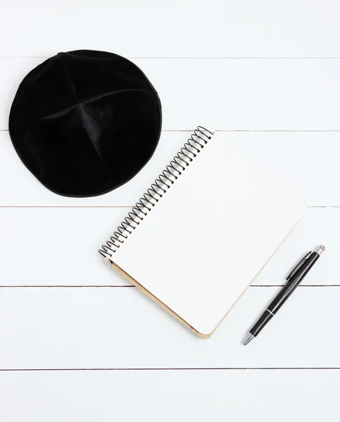 Defter, kalem ve arka kipa Beyaz ahşap zemin, üstten görünüm üzerinde. Yahudi yeni yılı, Rosh Hashanah
