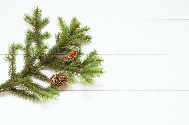 Beyaz ahşap zemin üzerinde koniler ile Ladin dal. Yeni yıl, Noel. Tonlu görüntü, film etkisi