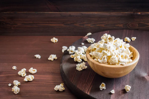 Salt popcorn na dřevěný stůl — Stock fotografie
