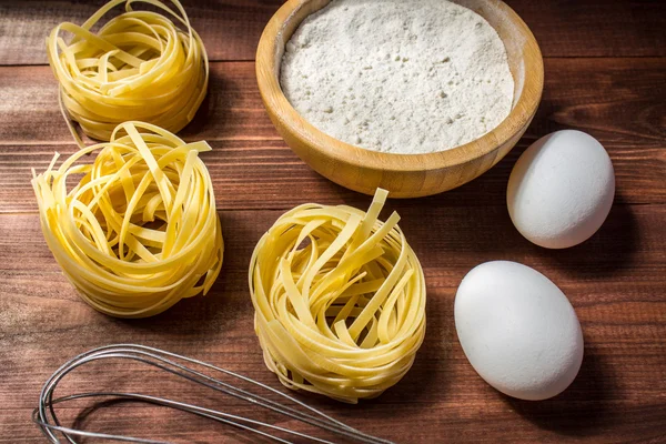 Αυγά, αλεύρι και φετουτσίνι με φόντο ξύλινη — Φωτογραφία Αρχείου