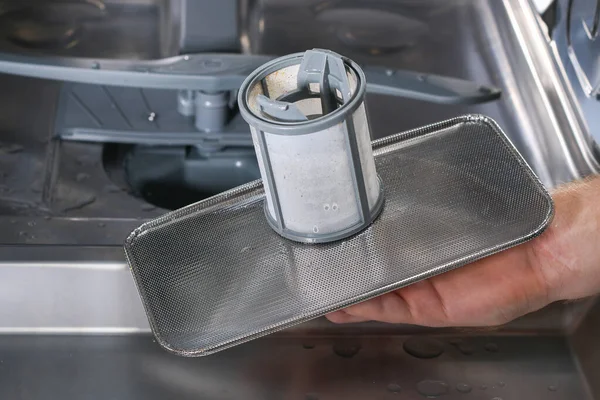 Adam bulaşık makinesindeki filtreyi söküyor..