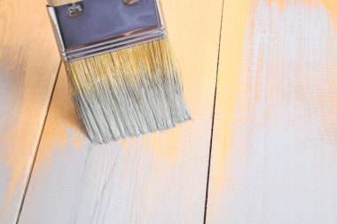 Elinde boya olan fırça. Bir adam gri boya fırçasına tahta çiziyor..