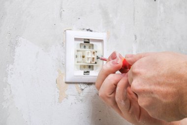 Bir işçi duvar kağıtları için ışık düğmesini kaldırır.