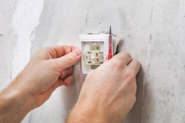 Bir işçi duvar kağıtları için ışık düğmesini kaldırır.