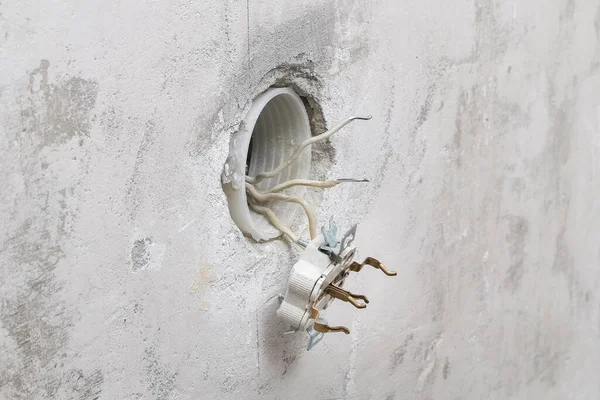 Um homem desmonta e conserta a tomada elétrica para reparos. Tomada de energia. — Fotografia de Stock