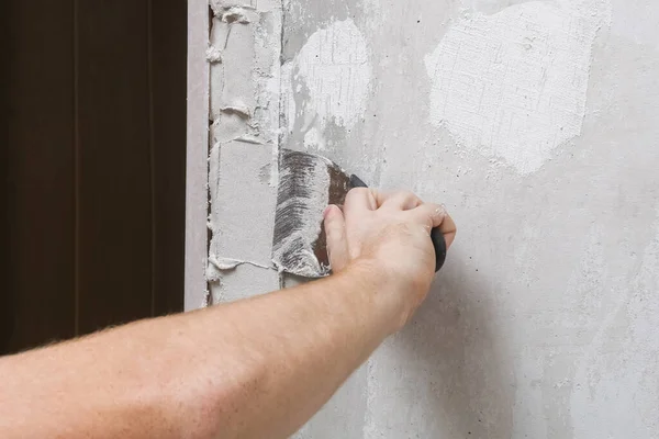 De man pleistert de muren in de kamer. Close-up. — Stockfoto