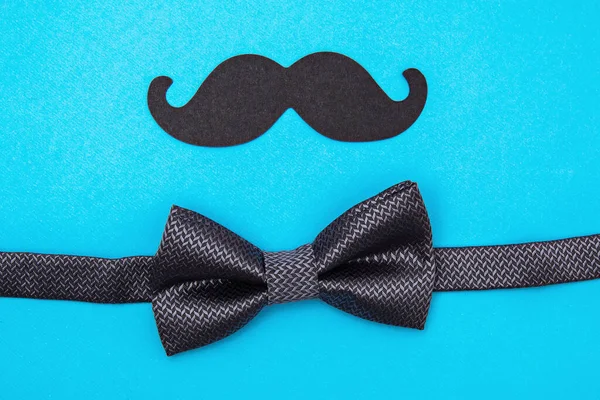 Fathers day card background on blue background. Composition of tie, bow tie, mustache. Fathers day