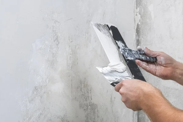 Um trabalhador do sexo masculino espalha a mistura de massa de vidraceiro e achata parede. — Fotografia de Stock