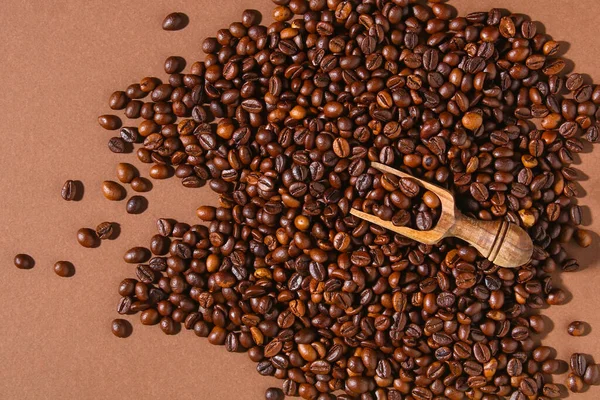 Roasted brown coffee beans on a brown background. — Stock Photo, Image