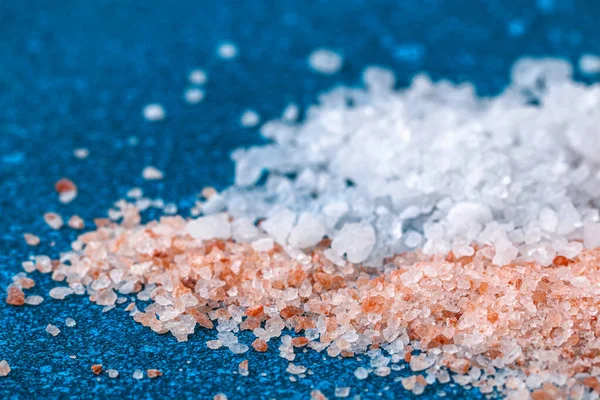 Ροζ χοντρό αλάτι κρύσταλλα στο μπλε τραπέζι. Αλάτι Ιμαλάια. Ιστορικό για διαφήμιση αλμυρή. — Φωτογραφία Αρχείου