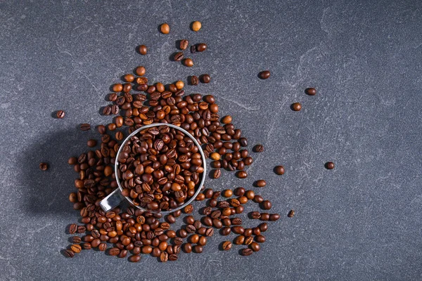 Rostade bruna kaffebönor på en grå bakgrund. — Stockfoto