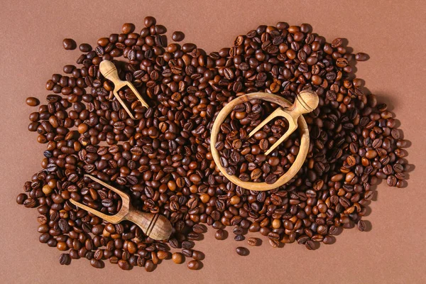 Grãos de café torrados em um fundo marrom. — Fotografia de Stock