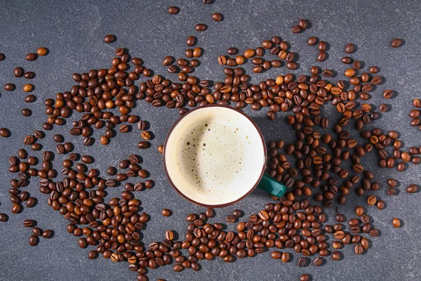 Taza de café en una mesa gris con granos de café y hojas de café. —  Fotos de Stock