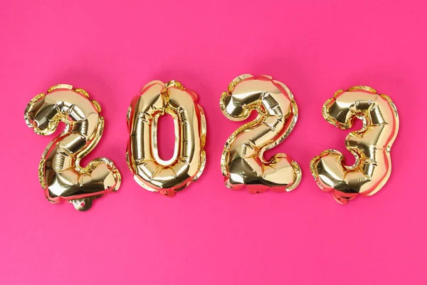 Yeni yıl 2023. Pembe arka planda 2023 numaralı folyo balonları. Yeni yıl Noel 'i.