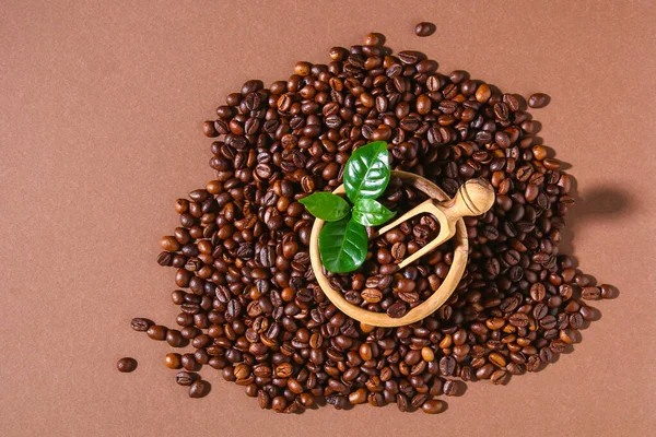 Grãos de café torrados em um fundo marrom. — Fotografia de Stock