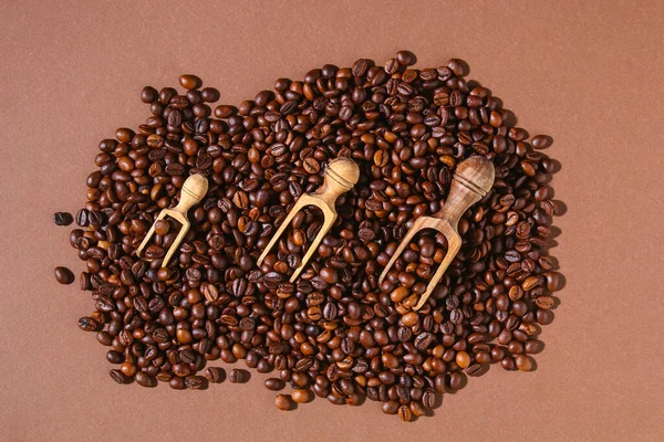 Roasted brown coffee beans on a brown background. — Stock Photo, Image