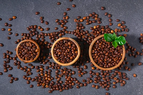 Granos de café tostados sobre un fondo gris. —  Fotos de Stock