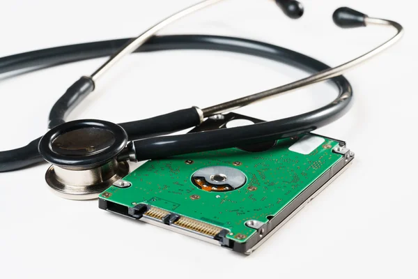 Stethoscope and hard disk drive on white background Stock Photo