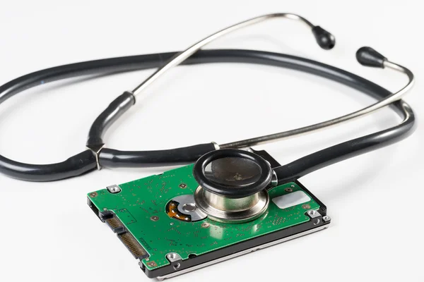 Stethoscope and hard disk drive on white background Royalty Free Stock Photos