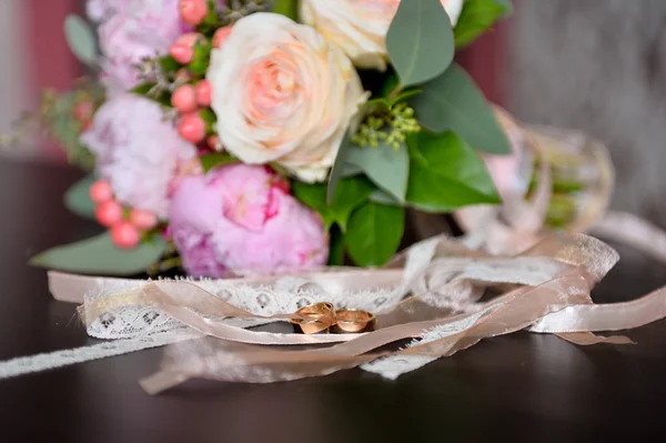 Ramo de novia en la mesa, junto a los anillos —  Fotos de Stock